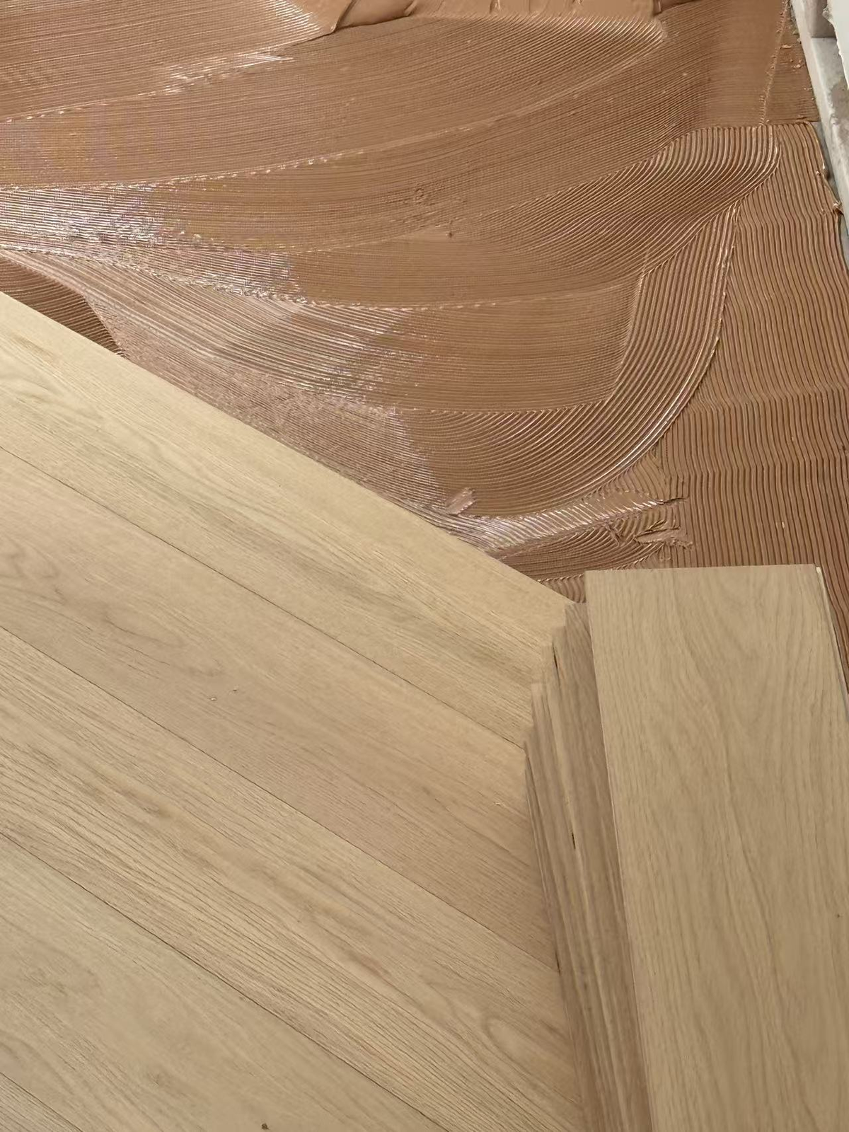Installer applying SETTO Supreme S75 to a prepared subfloor